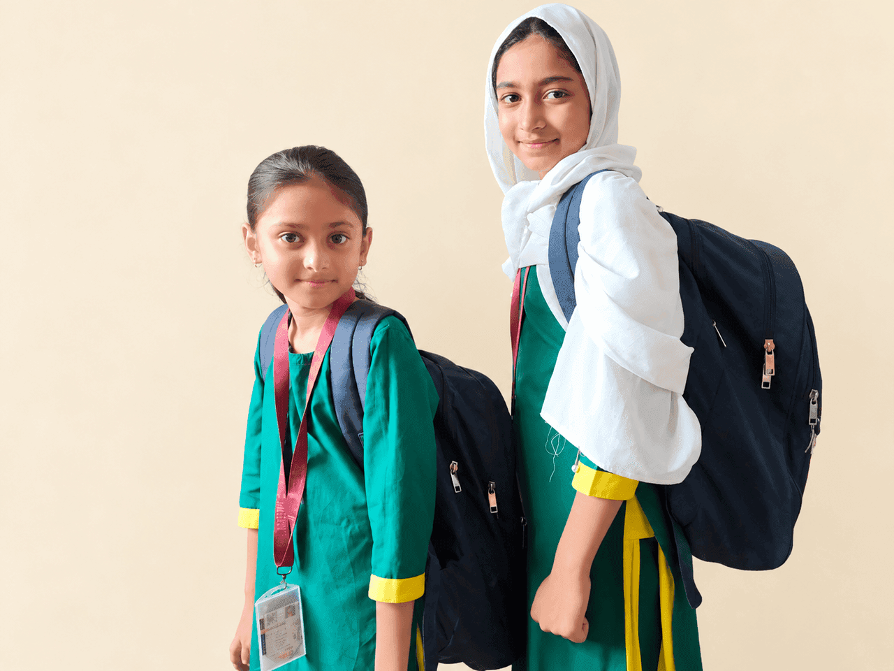 Two students in school uniform with their school bags