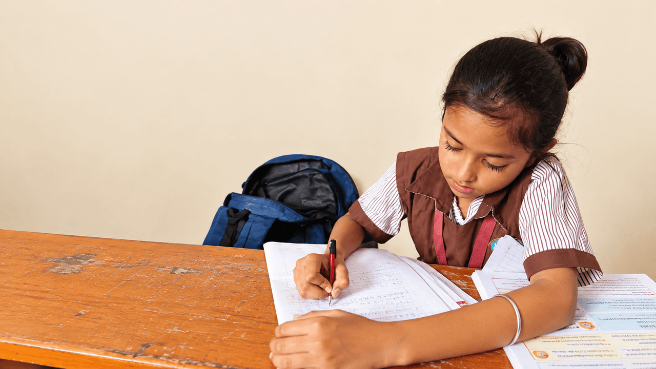 A student of The Progress Academy writing in her notebook